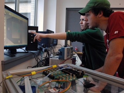 Mechanical engineering seniors Katie Stanchak, pointing, and David Shafer are working on a team developing a surgical robot capable of performing surgery via computer through a haptic device.