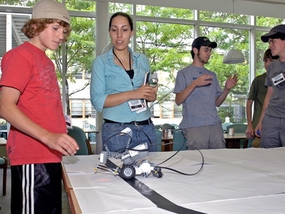 Raquel Velez mentors a student during ROLL's Weekend Robotics Workshop.
