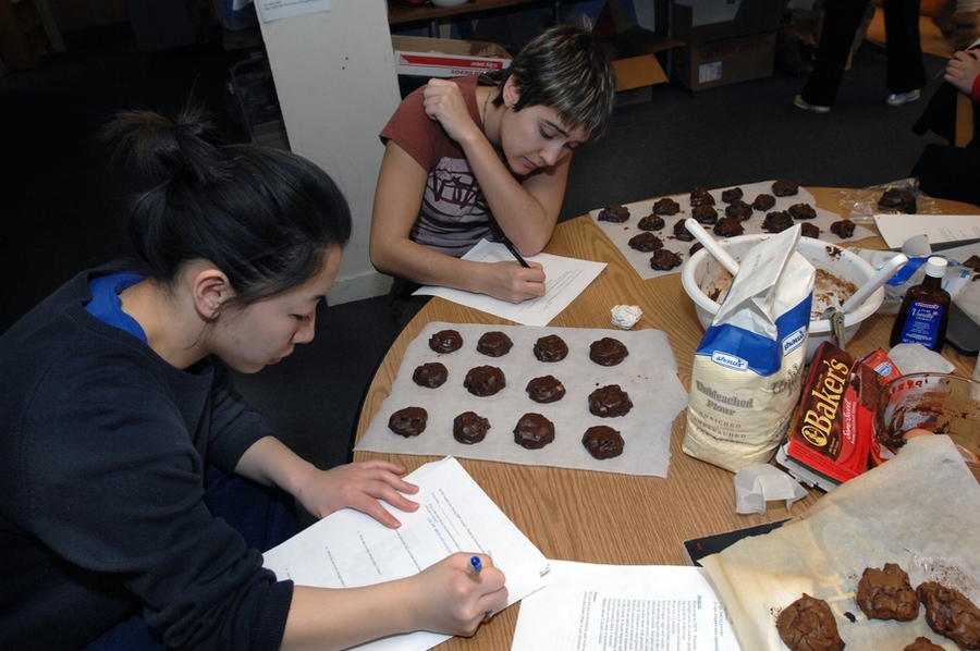 Senior Angie Chiang, foreground, and junior Taylor Williamson write notes on the chemistry they have learned by making "Death by Chocolate" cookies in Patti Christie's Kitchen Chemistry course, offered in the ESG kitchen.