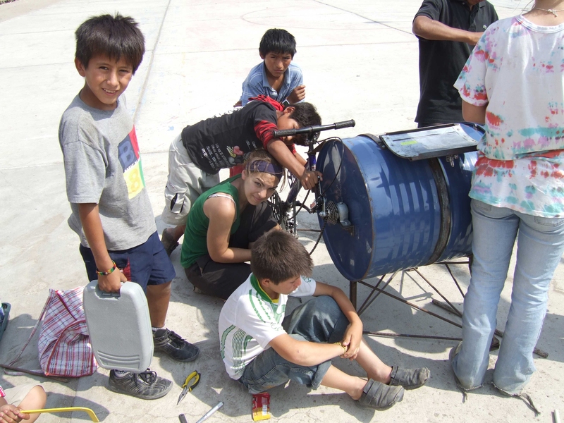 MIT students and residents of Ventanilla, Peru work on the bicilavadora, a novel, inexpensive bike/washing machine.