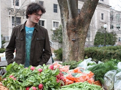Josh Bails, a sophomore in the Department of Brain and Cognitive Sciences, checks out East Campus' new produce stand during its first day of operation on March 31.
