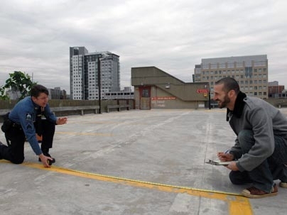 Sgt. Cheryl Vossmer of the MIT Police, left, and Libraries Administrative Assistant and Public Service Support Associate Ryan Gray measure parking space atop West Garage where vegetables, flowers and herbs will take the place of cars in MIT's first-ever community garden.