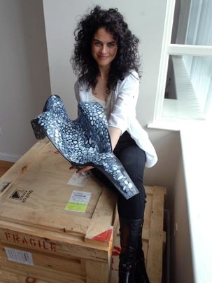 Neri Oxman poses in her studio with a model of a molded chaise longue that drew inspiration from the internal structure of bones and other biological forms.
