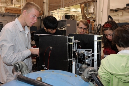 Left to right: Graduate student and Air Force Lieutenant Joseph Robinson and seniors Arthur Huang, Ryan McLinko, Victoria Stolyar, and Virginia Quaney perform vibration testing on satellite components at Lincoln Laboratory's Environmental Test Laboratory.