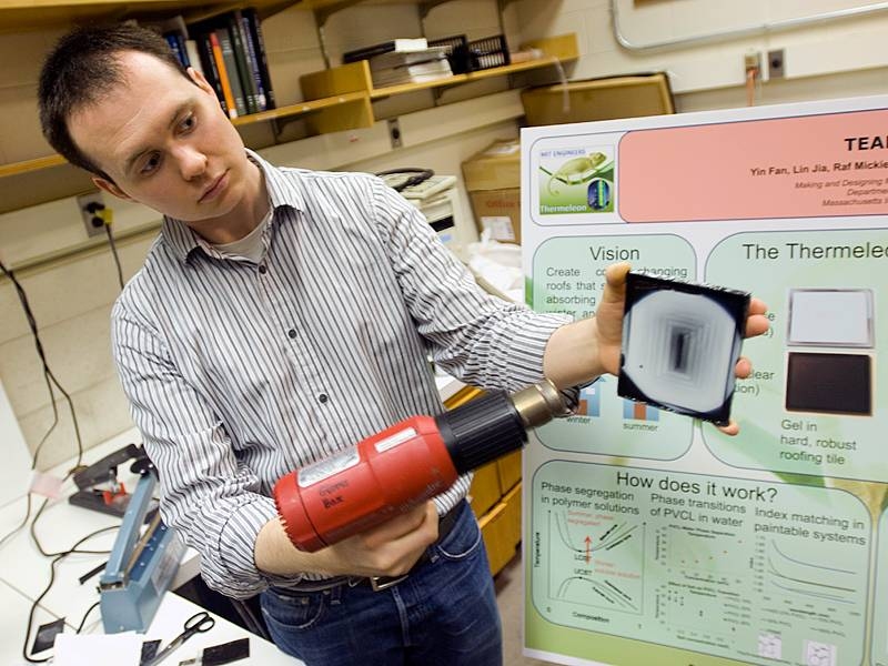 Nick Orf PhD ’09 demonstrates a prototype Thermeleon roof tile, using a heat gun to warm part of it. The heated area turns from black to white.