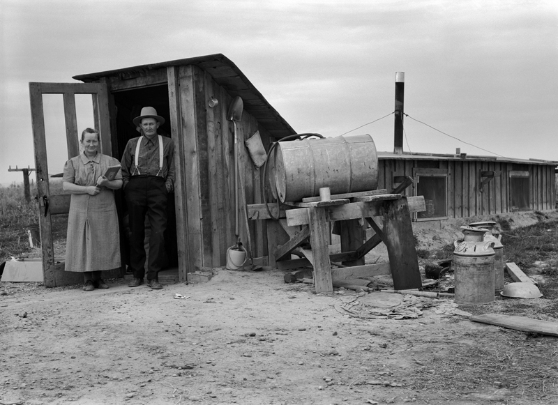 The Wardlaw couple at entrance of basement dugout home.