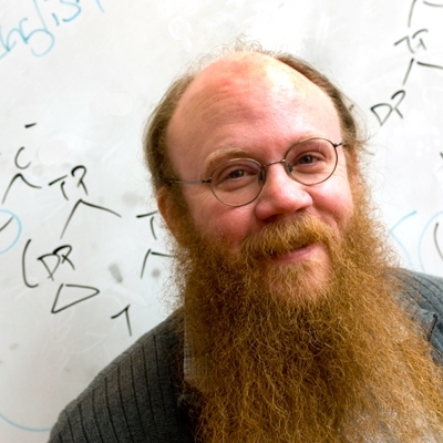 MIT linguistics professor Norvin Richards stands in front of a tree-like sentence diagram often used by linguists.