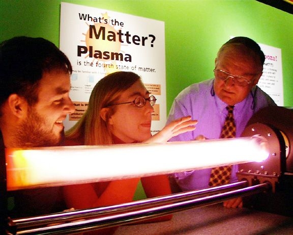 For Outreach Days, Paul Thomas, here assisted by graduate students, uses a glow discharge tube to demonstrate some of the properties of plasma.