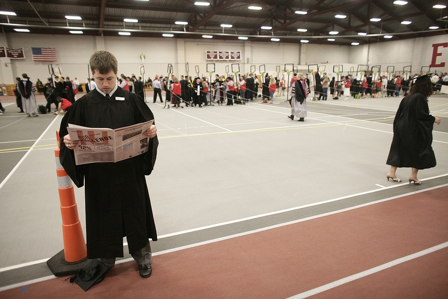 A graduating student reads a copy of The Tech, the MIT student newspaper, while waiting to line up prior to the Commencement exercises.