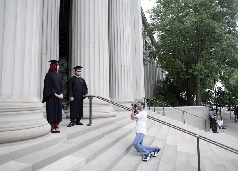 Soon to be graduates have their picture taken in front of MIT's Building 7.