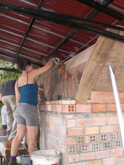 Samantha Cohen ’11 of civil and environmental engineering lays bricks for the vaulted roof of the pantry. 