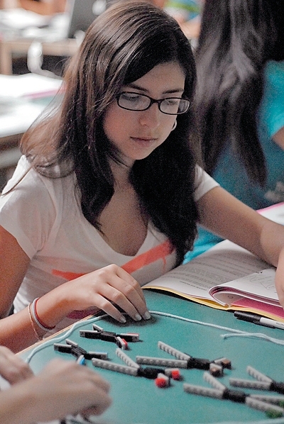 A student in the outreach program learns the steps of meiosis using LEGO chromosomes.  