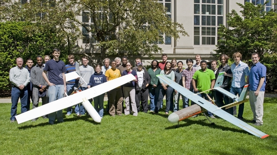 MIT students and faculty who worked on the unmanned aerial vehicle for Lincoln Laboratory are seen here with their first model on the left and the near-final product on the right.