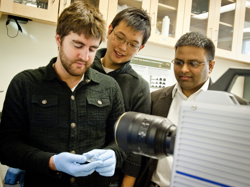 Kripa Varanasi, right, a professor of mechanical engineering, and graduate students Hyuk-Min Kwon, center, and Adam Paxson stand in front of the high-speed camera used to capture images of water droplets on a surface.