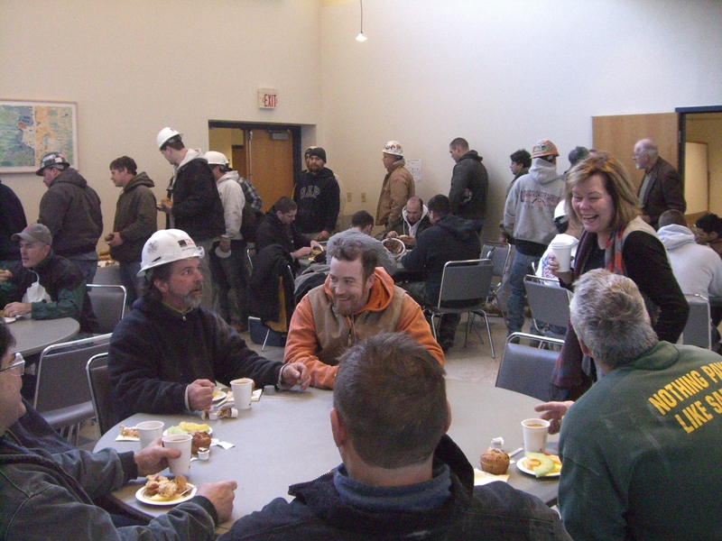 Maseeh Hall Headmaster Suzanne Flynn, right, chats with construction workers at the coffee hour.