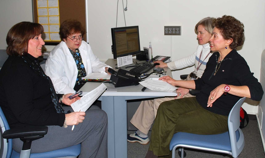 Staff in MIT Medical's Community Care Center discuss patient care. Left to right: nurse care managers Kim Carroll, Cathy Dwyer, Eleanor Woodard and Marie Avelino.