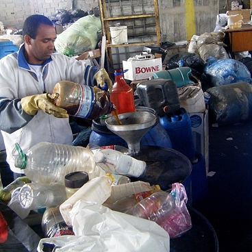 A member of the Rede CataSampa waste-pickers cooperative demonstrates the filtration system for waste vegetable oil that was set up with the help of MIT students.