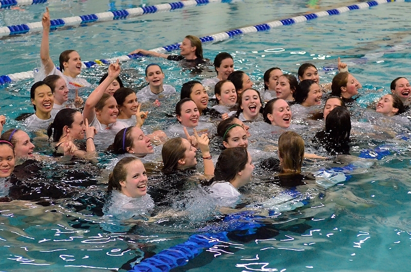 Following a meet tradition, the winning MIT women tossed head coach Dawn Dill (center rear, holding the lane marker) into the pool — then jumped in to join her.