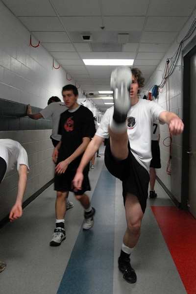 After changing in one of the locker rooms, the players did some stretching in the cramped hallways underneath the arena. Junior Jacob Steinhardt warmed up with some high kicks.
