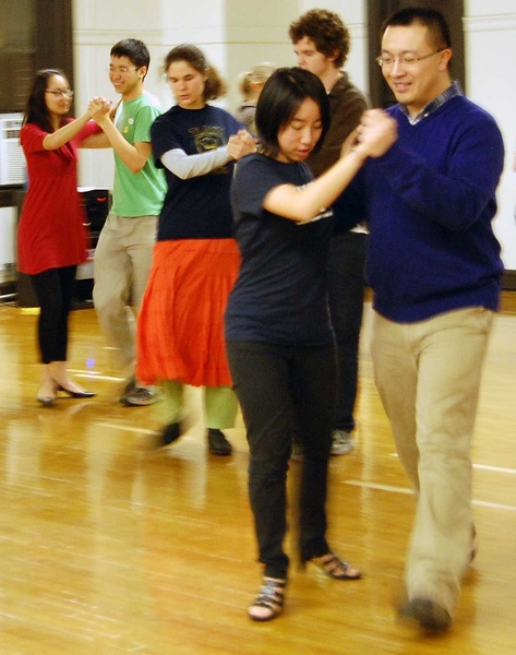Students in the ballroom dance class are all smiles as they practice their steps.