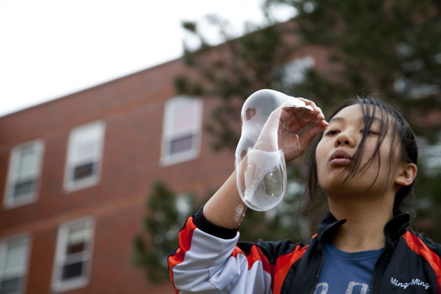 Prefrosh Ming Ming Tran blew soap bubbles with her hand in the courtyard between New House and Next House.