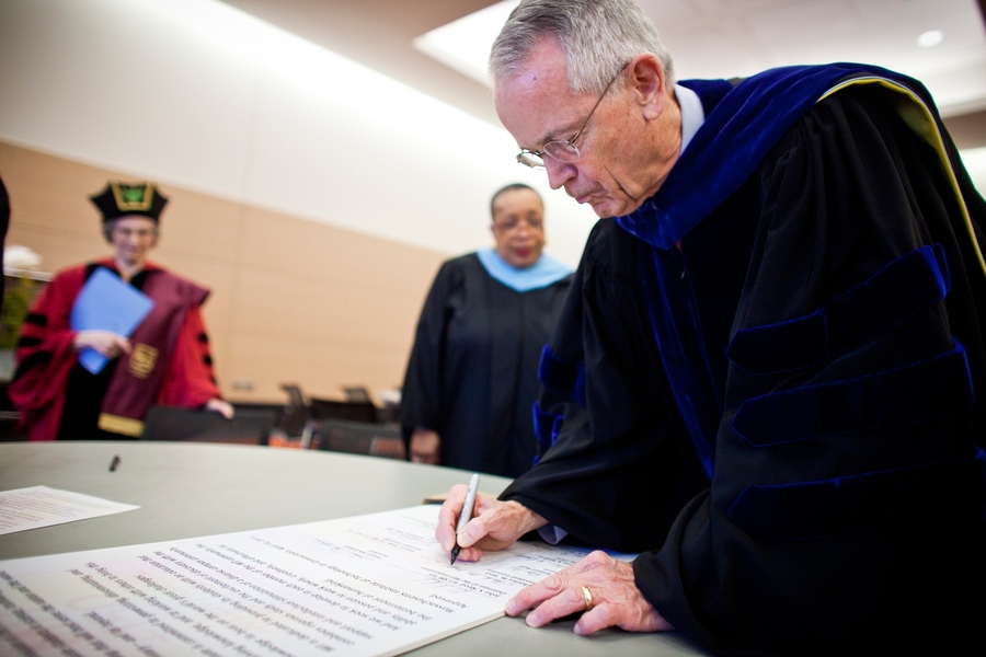 President emeritus Charles Vest signs the charter renewal, after an electronic, iPad 'iCharter' was signed on stage.