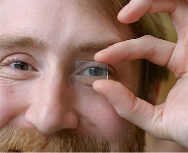 Richard Lunt, one of the researchers who developed the new transparent solar cell, demonstrates its transparency using a prototype cell.