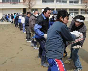 Japanese citizens receive food from a U.S. Navy helicopter as part of a disaster-relief and humanitarian-assistance operation.