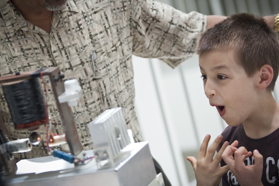 8-year-old Dylan, right, reacts to the demonstration of electromagnetism by Technical Instructor Lourenco Pires of EECS.