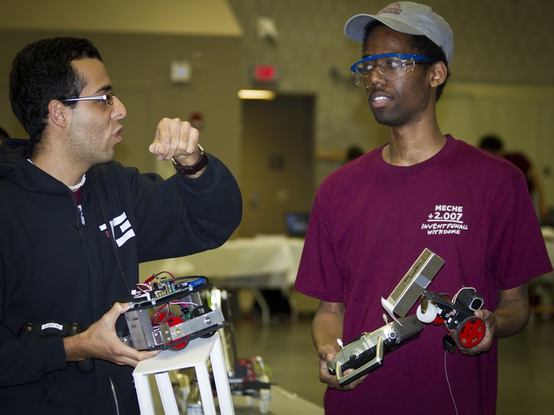 Sophomore Steven Obiajulu, right, holds one of his robots while talking to classmate Juan Felipe Carrillo.