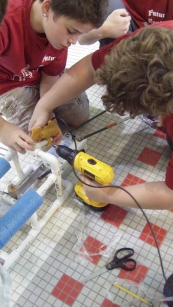Students work on a Sea Perch ROV poolside