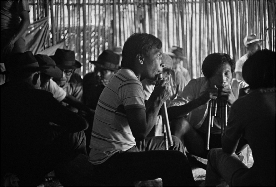 Participants play panpipes during mass celebration.