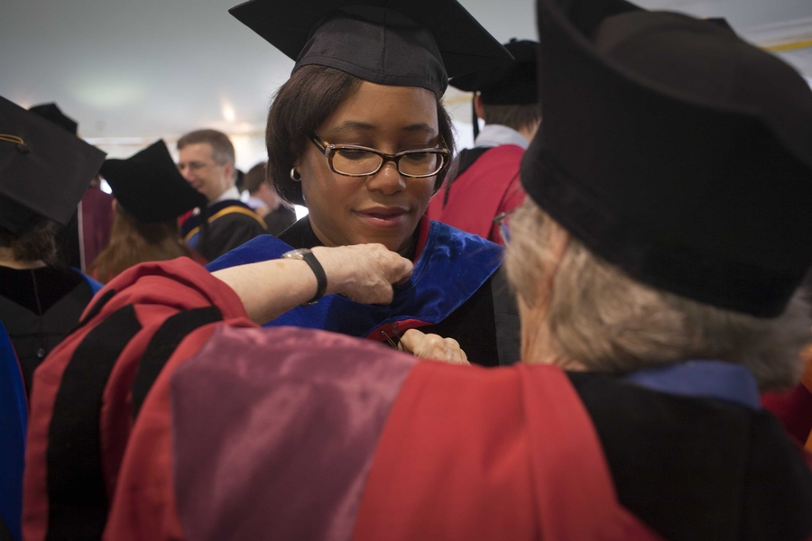 Professor Paula Hammond is assisted in getting ready for the procession by Professor Lotte Bailyn.