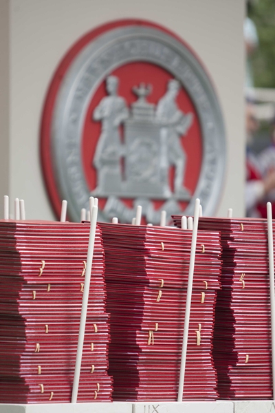 Diplomas wait on stage, neatly stacked and meticulously ordered to make sure each graduate receives the correct one.