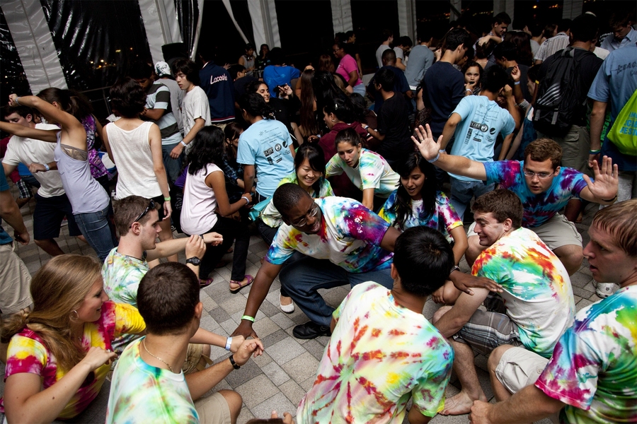 Student volunteer orientation leaders — identifiable by their tie-dye shirts — celebrate their last night on the job with some dancing in the tent on the wharf.