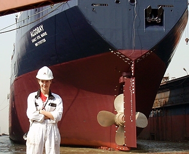 Alicia Lenis, LGO ’13, stands in front of one of the ships she worked on at the Chengxi Shipyard, Jiangyin, China in the fall of 2009.