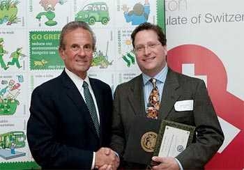 Richard C. Rossi, Cambridge deputy city manager, presents Steven M. Lanou, deputy director for sustainability in the MIT Environment, Health, and Safety Headquarters Office, with a City of Cambridge Go Green Award for MIT's achievements in energy programs. 
