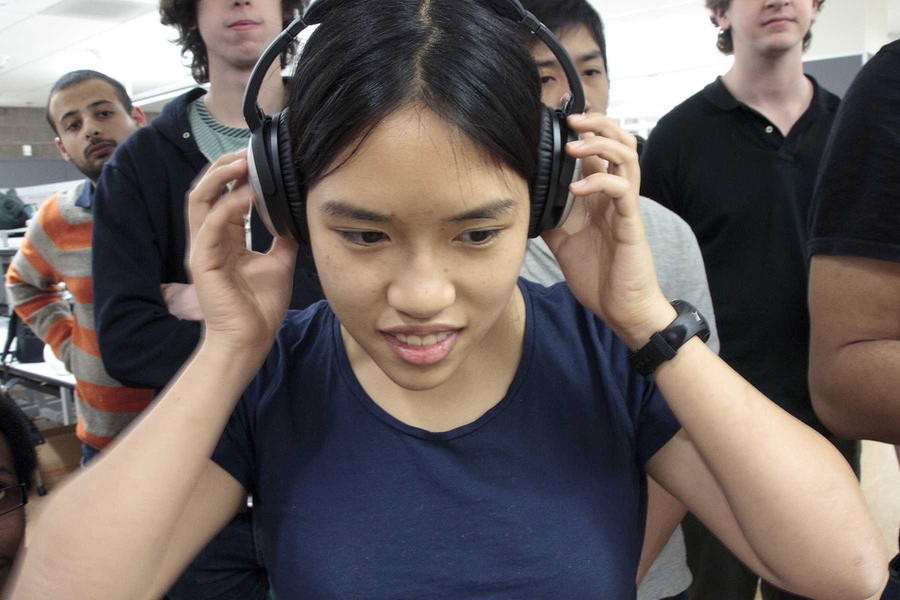 Senior Lauren Chai tries out a set of Bose noise-cancelling headphones as recordings ranging from jet engines to clothes dryers play loudly over the student-made speakers.