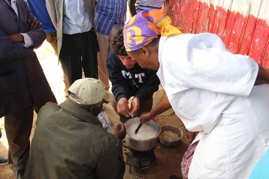 Using carbonized charcoal dust he made in a demonstration to dozens of Kenyans, junior Jacob Young, center, cooked porridge. Young’s next step will be to use agricultural charcoal, rather than wood charcoal, to help to prevent deforestation, which is a significant environmental problem around Nairobi.