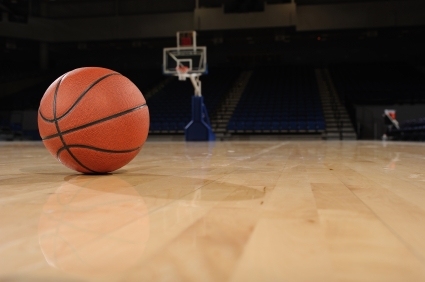 A basketball is on court with empty stadium seats