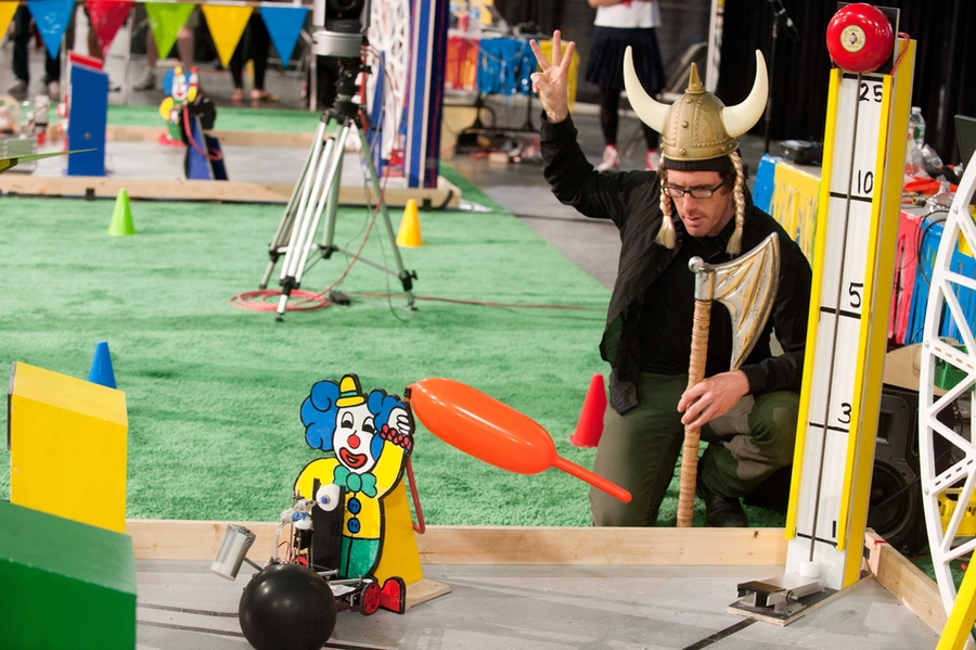 One of the class's teaching assistants, acting as a judge in the competition, indicates a robot's score on the balloon-inflation task (which was based on how far the balloon inflated).
