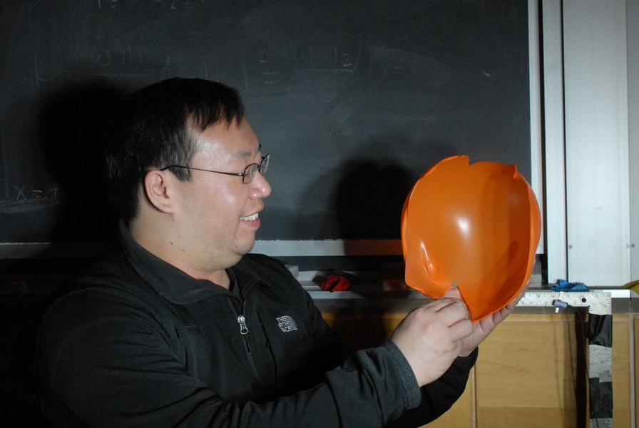 Allen Wong pops a balloon.