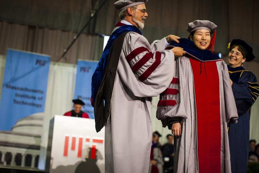 Doctoral students receive their hoods from administrators and faculty from their school, department or program.