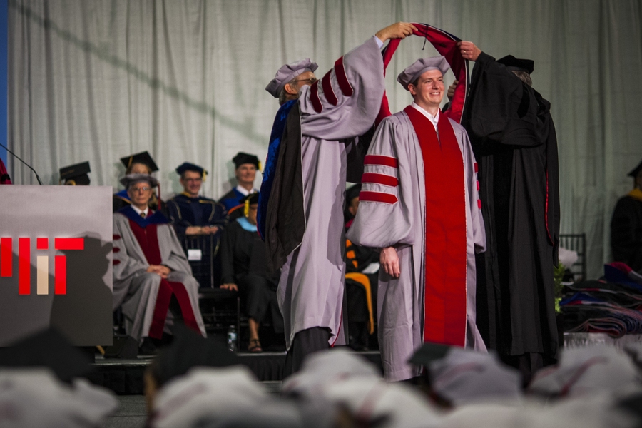 Doctoral students receive their hoods from administrators and faculty from their school, department or program.