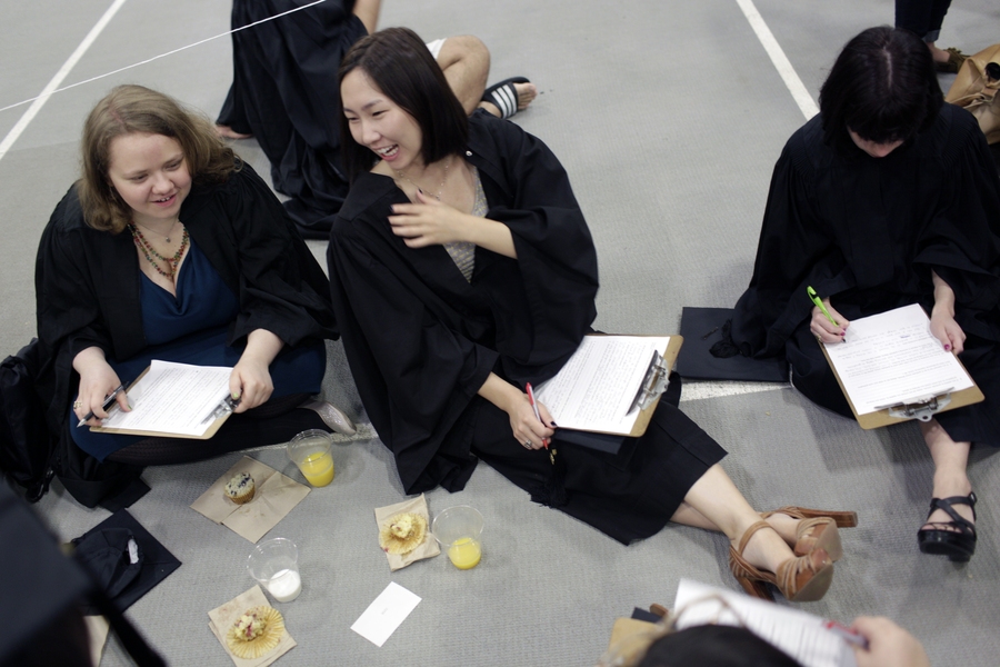 Graduating students sit on the floor of Rockwell Cage, prior to lining up.