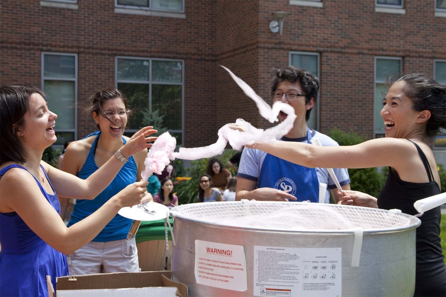 MIT students make cotton candy at the Sidney-Pacific 10th Anniversary Brunch and Carnival (L-R: Michelle Sander PhD '12, Christin Sander G, Chen Lu G, Jennifer Jarvis G).