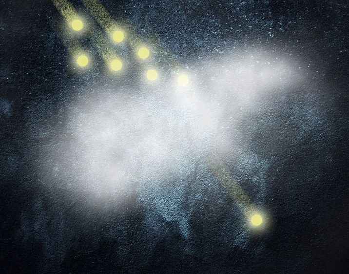 An artist's conception shows how any number of incoming photons (top) can be absorbed by a cloud of ultra-cold atoms (center), tuned so that only one single photon can pass through at a time. Being able to produce a controlled beam of single photons has been a goal of research toward creating quantum devices.