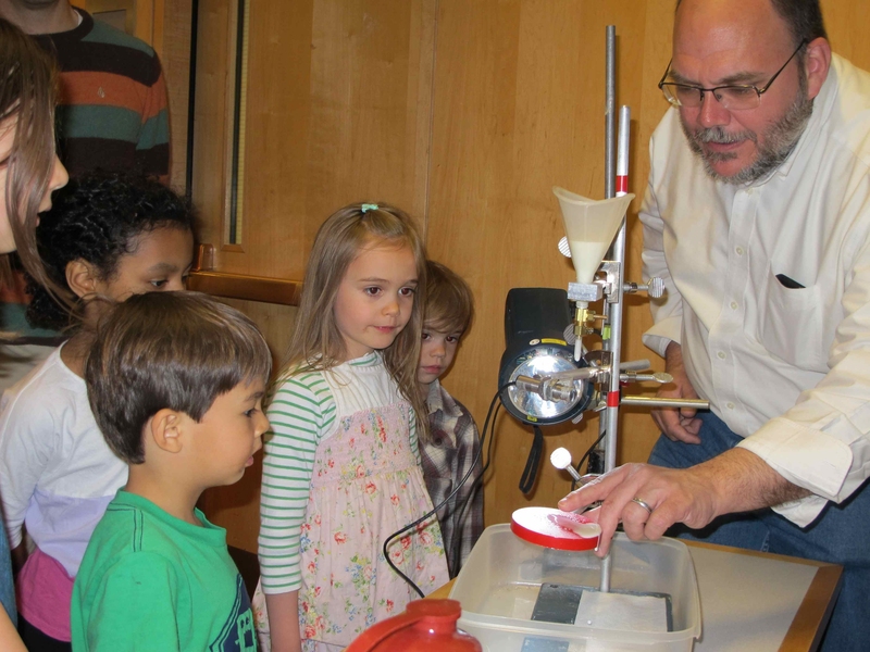 Dr. Jim Bales, assistant director at the Edgerton Center, explains how the strobe light captures the milk splash at the third annual Obscura Day where the community can explore unusual and fascinating places. Bales is the instructor for 6.163 Strobe Project Laboratory, the class that Doc Edgerton taught. Left to right: Dane Robinson, Sophie Streeter, Beatrix Metral, Felix Betral and Bales.