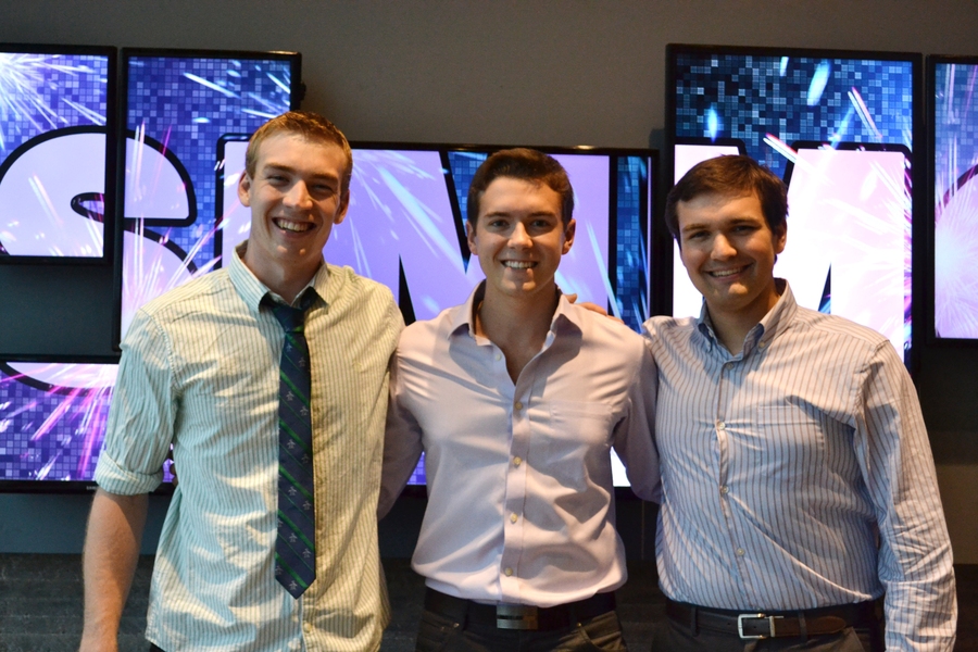 Simmons residents Sean Karson, Cosmos Darwinand Drew Dennison proudly stand in front of a 144&#39; paneled display they helped put together for the anniversary.