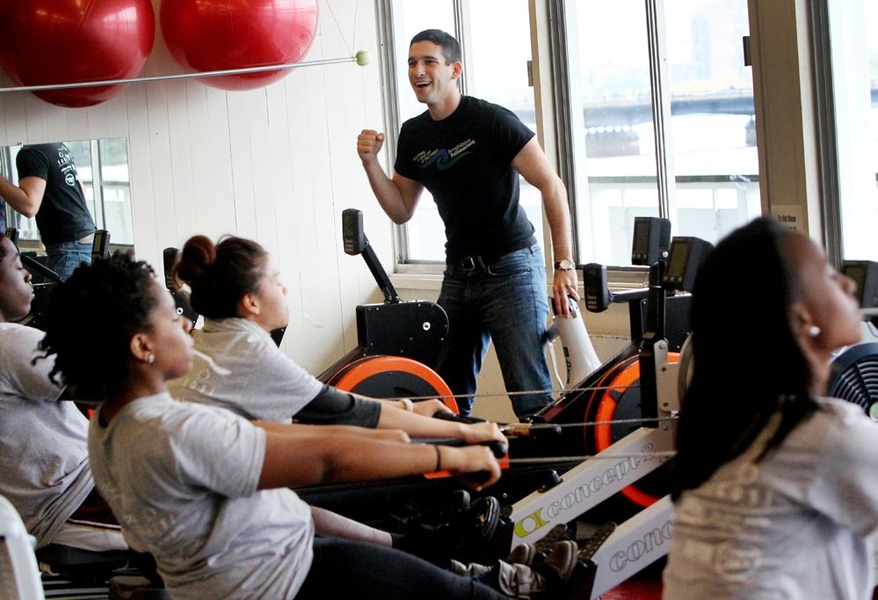 Angrist celebrates as the Achievers rock back and forth with their eyes closed and in perfect synchronization on the Ergonomic rowing machines (or 'ergs') to the song 'Lean Wit' It, Rock Wit' It' — a signature drill he designed to teach rowers how to use correct body swing technique.